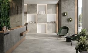 Ein modern gestalteten Empfangsbereich mit einem eleganten, minimalistischen Design. Der Raum ist geprägt von großformatigen Boden- und Wandfliesen aus der Serie Baltico, die in natürlichen Grautönen gehalten sind. Die Fliesen zeichnen sich durch ihre matte Oberfläche und ihre natürliche Steinoptik aus, die dem Raum eine ruhige und edle Atmosphäre verleihen.  Die hochwertigen Fliesen verlaufen nahtlos vom Boden bis zu einzelnen Wandflächen und schaffen ein harmonisches Gesamtbild.
